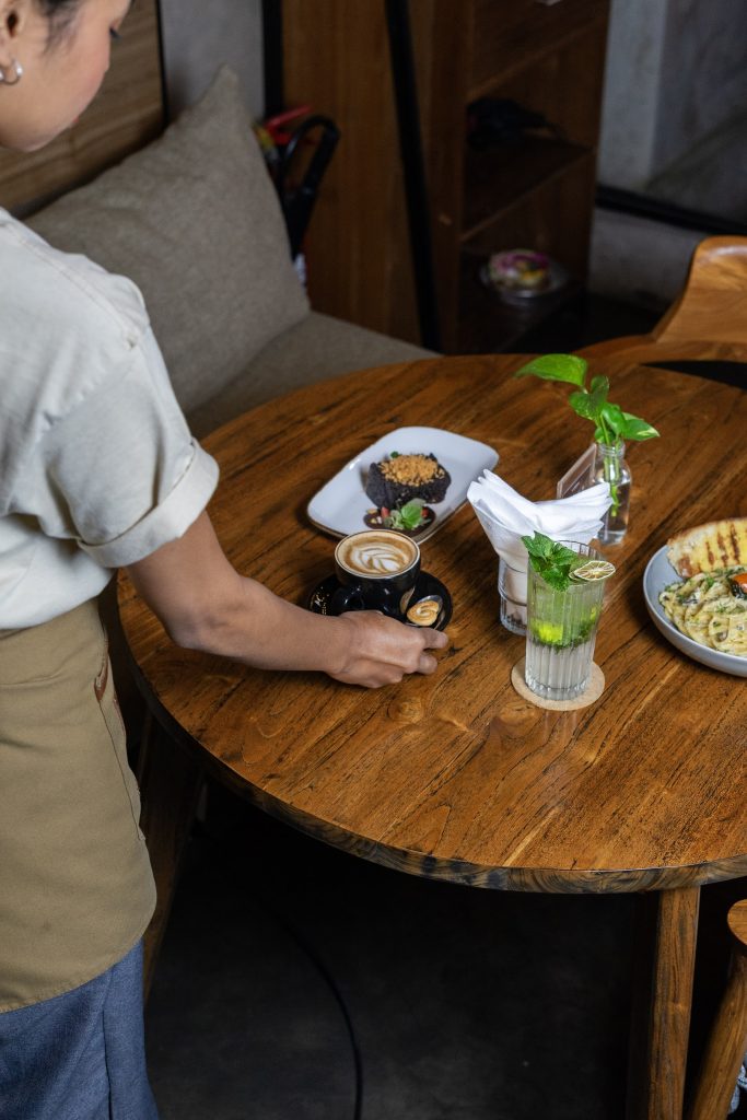 Server setting a table at Camino Resto & Bar